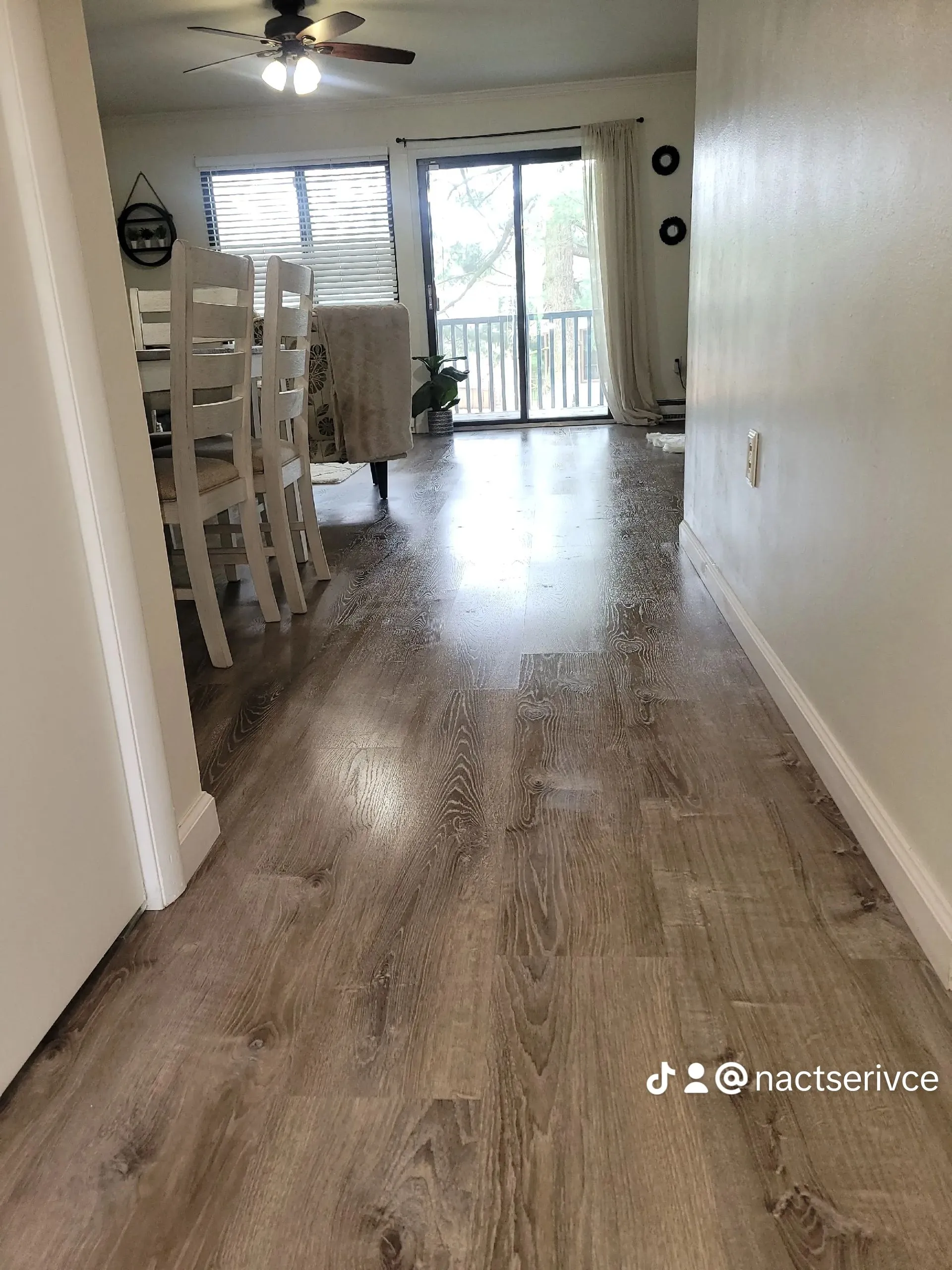 Clean and shiny hardwood floors in an Airbnb dining area with white chairs and natural light