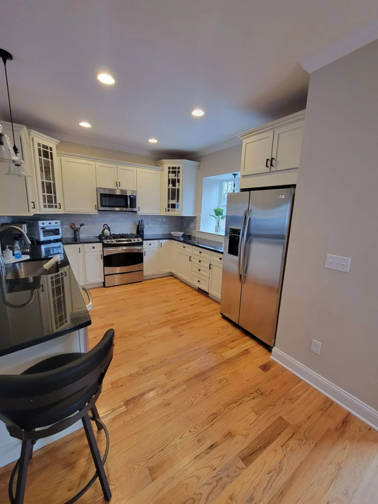 Freshly cleaned modern kitchen in an Airbnb with recessed lighting and stainless steel appliances