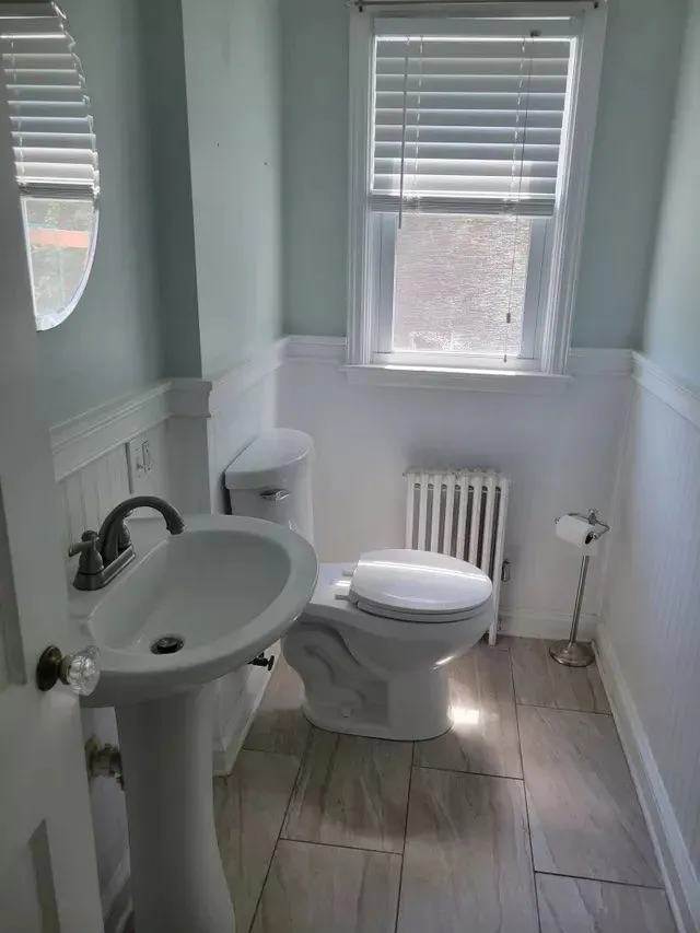 Clean white pedestal sink and toilet in a spotless bathroom in Bristol, CT.