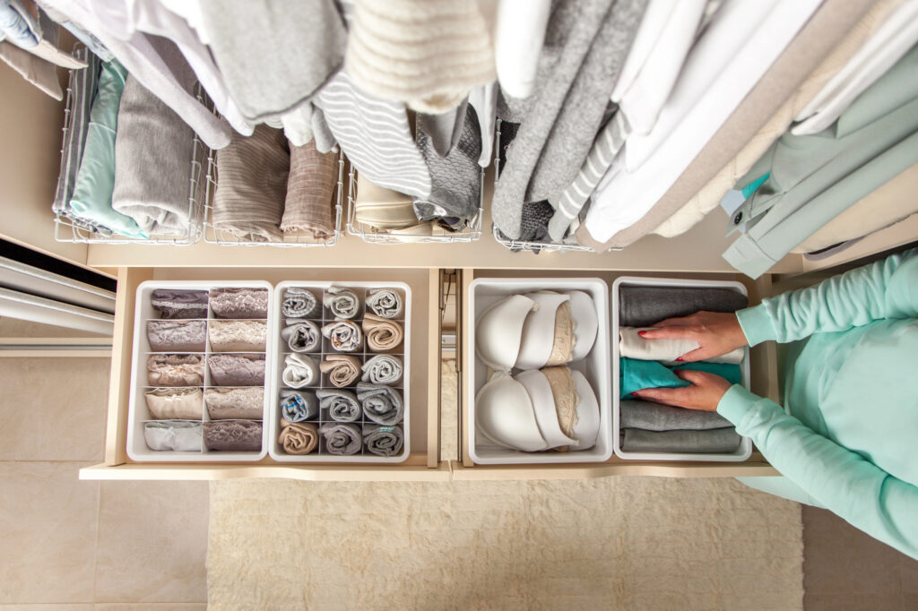 Organized closet and folded clothes in drawers during a professional home decluttering session