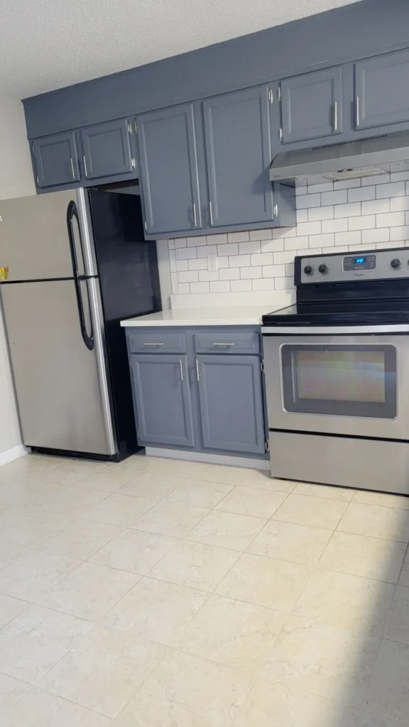 Spotless kitchen with stainless steel appliances and freshly cleaned blue cabinets in Bristol, Connecticut