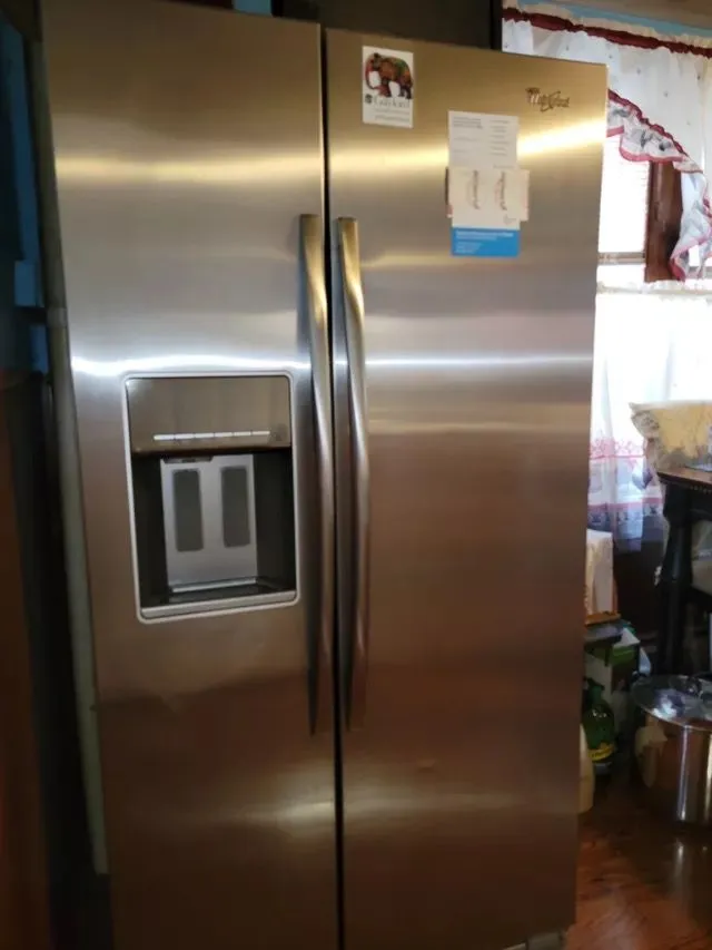 Stainless steel double-door fridge in a well-lit New Haven, CT kitchen