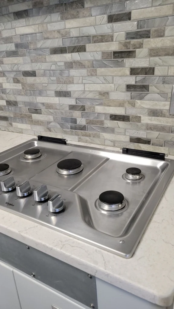 Close-up of a freshly cleaned stainless steel stovetop and backsplash in Bristol, Connecticut