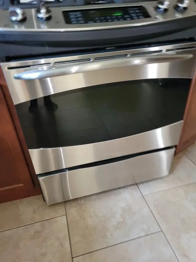 Clean stainless steel oven with black glass front in New Britain, CT kitchen